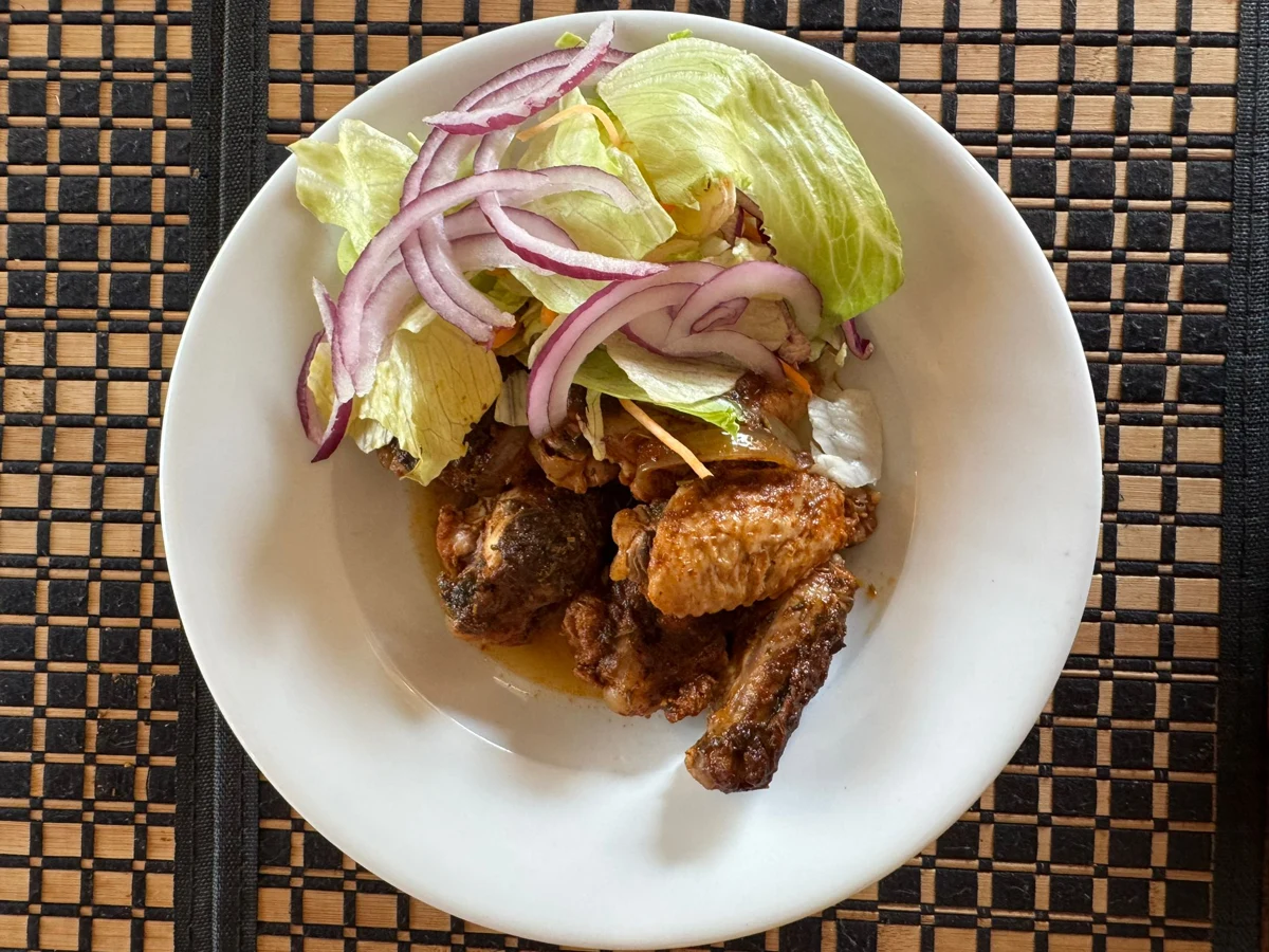 Jerk chicken wings served with salad and sliced red onion at KC’s.